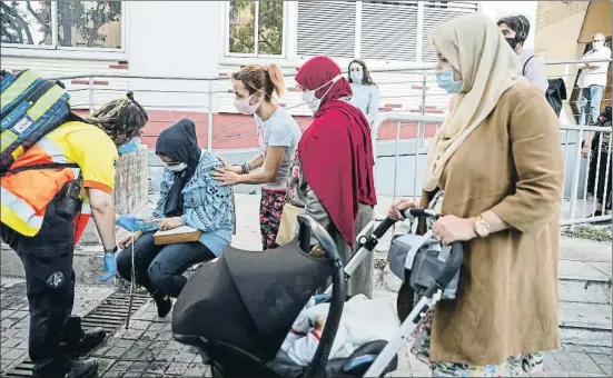  ?? ÀLEX GARCIA ?? Una de las mujeres de la Salut alojadas en un pensión temporal, atendida por los sanitarios por un crisis de ansiedad