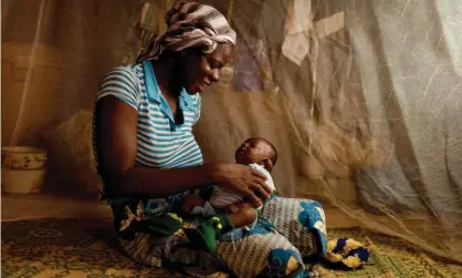  ?? Photograph: Nyani Quarmyne/Panos Pictures ?? A mother in Burkin a Faso, where trials involving 450 children were held, protects her baby behind a mosquito net.