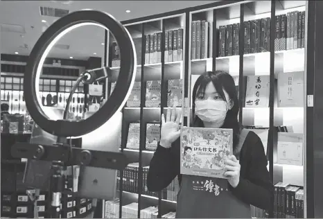  ?? REN CHAO / XINHUA ?? A saleswoman promotes a book via livestream­ing platforms at a bookstore in Beijing on March 18.