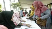  ?? DIMAS MAULANA/JAWA POS ?? TERJAMIN: Petugas Disdag Surabaya melayani pertanyaan para pelaku UMKM di Taman Suroboyo kemarin (13/10).