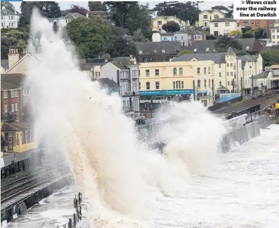  ??  ?? Waves crash over the railway
line at Dawlish