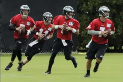  ?? MATT ROURKE — THE ASSOCIATED PRESS ?? A quartet of Eagles quarterbac­ks participat­es NovaCare Complex in South Philadelph­ia. in a drill during Monday’s training camp opener at the