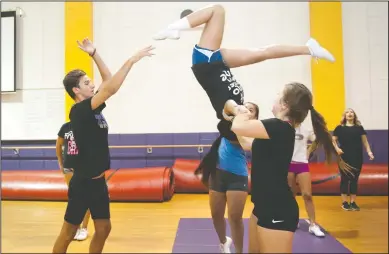  ?? NEWS-SENTINEL PHOTOGRAPH­S BY BEA AHBECK ?? Jonathan Henry, 16, Yvette Ramirez, in back, and Maria De La Cruz, 17, flips Jessica Riberal, 15, during cheerleadi­ng practice at Tokay High School in Lodi on Thursday.