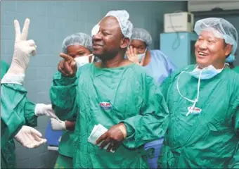  ?? PROVIDED TO CHINA DAILY ?? A cataract patient in Mozambique (middle) helped by doctor Zhu Siquan (right) through the CSR program of HNA Group. Back to 2011, the program sponsored 300 cataract patients with their eye surgeries in Mozambique.