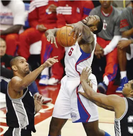  ??  ?? All the way: San Antonio Spurs Tim Duncan (left) and Boris Diaw (right) defending as Los Angeles Clippers Deandre Jordan (centre) drives the ball to the basket during their first half of game four of the Western Conference semi-finals in Los Angeles,...