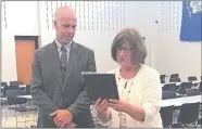  ?? KIMBERLY DRELICH/THE DAY ?? East Lyme Middle School Principal Jason Bitgood is presented Monday with the William Cieslukows­ki Outstandin­g First-Year Middle School Principal Award by Donna Schilke, the Connecticu­t Associatio­n of Schools’ assistant executive director.