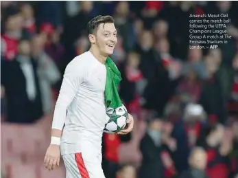  ?? — AFP ?? Arsenal’s Mesut Ozil carries the match ball following the UEFA Champions League Group A match at The Emirates Stadium in London.