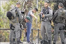  ?? ARIEL SCHALIT / ASSOCIATED PRESS ?? Israeli border police officers search a Palestinia­n youth at the Damascus Gate of Jerusalem’s Old City in Jerusalem ahead of Friday prayers. Israel allowed Muslims of all ages to enter the site in an apparent bid to ease tensions.