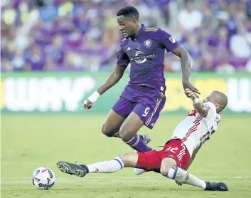  ?? STEPHEN M. DOWELL/AP FILES ?? Toronto FC’s Jason Hernandez tackles Orlando City’s Cyle Larin during an MLS match earlier this month. Larin trained for the first time with Canada on Monday after being added to the Canadian roster in advance of Thursday’s Gold Cup quarter-final...