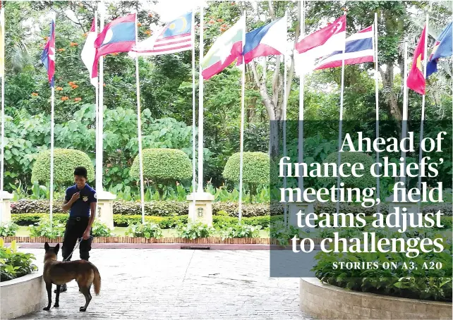  ?? SUN STAR FOTO/ALLAN CUIZON ?? A LITTLE HELP FROM A FRIEND. An officer and his trained dog check the main entryway to one of the ASEAN meeting venues in Mactan.