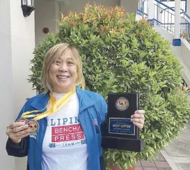  ??  ?? Author Kathy Moran with her medals and trophy. Thanks to Bench for the team T-shirts.