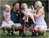  ?? EMILY MICHOT emichot@miamiheral­d.com ?? Addy Stromquist, with her father, Kyle Stromquist, Addie’s sister, Brooklyn Grant, and the girls’ mother, Ashley Grant, in front of their home in Cocoa, Florida.