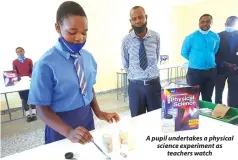  ?? ?? A pupil undertakes a physical science experiment as
teachers watch