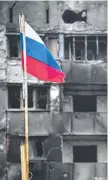  ?? Picture: Alexander Nemenov/afp ?? A Russian flag flies in front of a destroyed building in Mariupol on April 12.