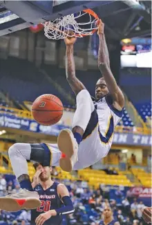  ?? STAFF PHOTO BY DOUG STRICKLAND ?? UTC forward Makinde London dunks in front of Samford’s Alex Thompson during Wednesday night’s SoCon matchup at McKenzie Arena. London had 21 points and grabbed a career-best 19 rebounds as the Mocs won 78-71 to end their losing streak at eight games.