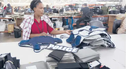  ?? J PAT CARTER/AP 2014 ?? Laurette Eugene assembles a body armor vest at the Point Blank Body Armor factory in Pompano Beach, Florida.