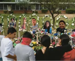  ?? JAE C. HONG/AP ?? People gather Monday at a memorial at Robb Elementary School in Uvalde, Texas, to pay their respects to the victims killed in last week’s school shooting.