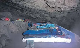  ?? FOTO: DPA ?? 300 Meter tief im Berg schlafen Männer, die das Hölloch in der Schweiz erkunden. Dort haben sieben Höhlenwand­erer auf ihre Rettung gewartet.