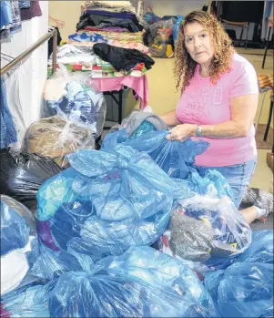  ?? SHARON MONTGOMERY-DUPE/CAPE BRETON POST ?? Brenda Corbett, a volunteer for the New Waterford Society of St. Vincent de Paul clothing depot in River Ryan sorts through bags of donated clothes that include some bags of items in such disgusting shape they’ll have to be taken to the dump. Corbett...