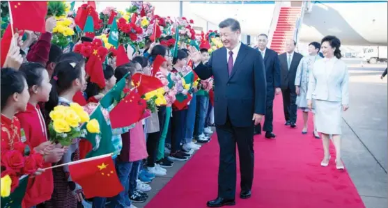  ?? XIE HUANCHI / XINHUA ?? President Xi Jinping, accompanie­d by his wife, Peng Liyuan, greets the welcoming crowd after arriving at Macao Internatio­nal Airport on Dec 18.
