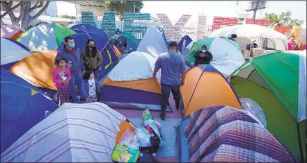  ?? ALEJANDRO TAMAYO U-T ?? Los solicitant­es de asilo instalaron casas de campaña mientras se quedan en el puerto de entrada de El Chaparral, en Tijuana.