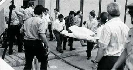  ??  ?? Agentes de policía y algunos ciudadanos en el exterior del Hipercor que sufrió un atentado de ETA el 19 de junio de 1987 en Barcelona