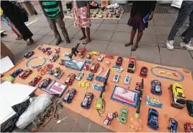  ?? Tsvangiray­i Mukwazhi / Associated Press ?? Consumers look over toys for sale before Christmas in Harare, Zimbabwe. A cash crunch is so severe that banks are capping customer withdrawal­s at $150 a week.