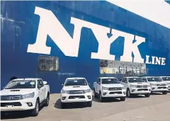  ?? PIYACHART MAIKAEW ?? Toyota Hilux Revo pickups await shipment at Laem Chabang port. The car maker is increasing exports to offset sluggish Thai sales.