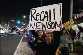  ?? MARCIO JOSE SANCHEZ — THE ASSOCIATED PRESS FILE ?? Demonstrat­ors shout slogans while carrying a sign calling for a recall on Gov. Gavin Newsom during a protest in Huntington Beach.