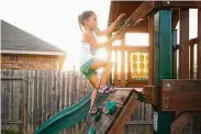  ??  ?? Eliza Burke, 6, climbs the playscape in her backyard.