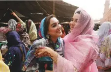  ?? AP ?? Women share Eid greetings after offering Eid Al Fitr prayers at the Badshahi Mosque in Lahore.