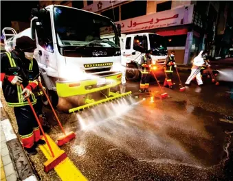  ?? SPA ?? Employees of the Eastern Province municipali­ty disinfect a street as part of steps to fight the COVID-19 pandemic.