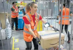  ?? ?? Empleados de Amazon preparan las rutas de los repartidor­es.