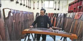  ?? ZHU XINGXIN / CHINA DAILY ?? In Xuchang village, a villager plays the guzheng at home.