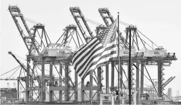  ??  ?? The US flag flies at the Port of Long Beach, in Los Angeles County. Just over a year after Congress enacted sweeping corporate tax cuts meant to jolt the economy, a shadow has crept into the picture – layoffs are also on the rise. — AFP photo