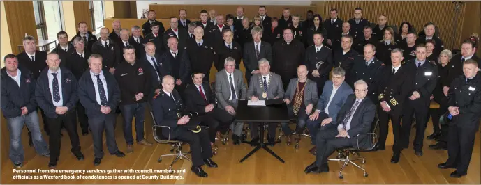  ??  ?? Personnel from the emergency services gather with council members and officials as a Wexford book of condolence­s is opened at County Buildings.