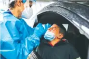  ?? AP PHOTO/ LUCA BRUNO ?? A medical staff member tests a boy for COVID-19 at a drive-thru at the San Paolo hospital, in Milan, Italy, on Thursday.