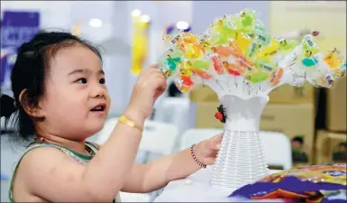  ?? PROVIDED TO CHINA DAILY ?? A child touches candies on display at an industry expo in Jinan, Shandong province.