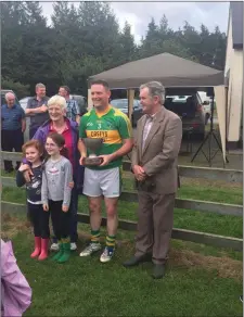  ??  ?? Captain Alan Smyth of Laragh accepting the Cullen Cup from Maire Cullen.