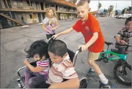  ??  ?? CHILDREN PLAY in the parking lot of the Country Inn. Surrounded by drugs and despair, they watch out for each other.