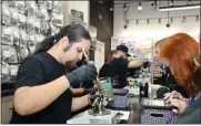  ?? ?? A budtender helps a customer select the right flower to purchase.