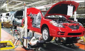  ??  ?? In this file photo, members of a production team work on the under carriage of a Toyota Solara convertibl­e on the assembly line at the Toyota Motor Manufactur­ing Kentucky plant in Georgetown, Kentucky. President Donald Trump’s relentless push for more...