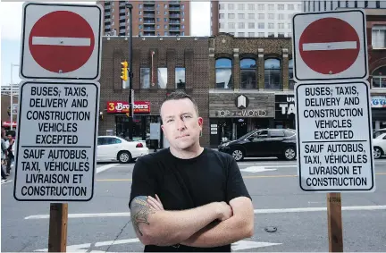  ?? DARREN BROWN/OTTAWA CITIZEN ?? Corey Hackett, co-owner of Top of the World, stands next to constructi­on signs on Rideau Street Thursday. The street is slated to close to car traffic for three years for LRT constructi­on, which Hackett fears will greatly affect his business and other...