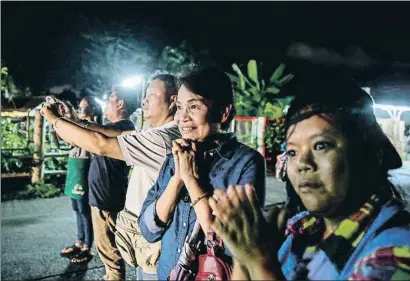  ?? LAUREN DECICCA / GETTY ?? Un grupo de curiosos aplaude la llegada de las ambulancia­s con los chicos al hospital de Chiang Rai