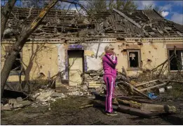  ?? FRANCISCO SECO — THE ASSOCIATED PRESS ?? Iryna Martsyniuk, 50, stands next to her house, heavily damaged after a Russian bombing in Velyka Kostromka village, Ukraine, Thursday. Martsyniuk and her three young children were at home when the attack occurred in the village, a few kilometers from the front lines, but they all survived unharmed.