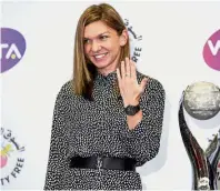  ?? — Reuters ?? Handsome prizes: Simona Halep of Romania posing with her ring and WTA world No. 1 trophy .