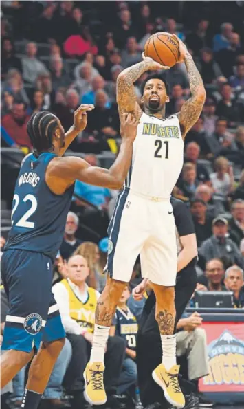  ?? John Leyba, The Denver Post ?? Nuggets forward Wilson Chandler fires a shot over Timberwolv­es forward Andrew Wiggins during Wednesday night’s game at Pepsi Center in Denver. The Nuggets lost 112-104.