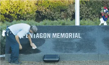  ??  ?? A MAINTENANC­E worker wipes off early morning dew at the Pentagon 9/11 Memorial in Washington DC.