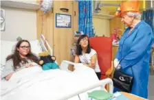  ?? THE ASSOCIATED PRESS ?? Britain’s Queen Elizabeth II, right, speaks to Amy Barlow, 12, from Rawtenstal­l, Lancashire, left, and her mother, Kathy, as she visits the Royal Manchester Children’s Hospital in Manchester, England, to meet victims of the terror attack in the city earlier this week and to thank members of the staff who treated them Thursday.