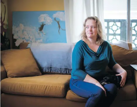  ?? DARRYL DYCK/THE CANADIAN PRESS ?? Joanna Fletcher sits with her foster dog in the one-bedroom apartment where she lives with her 10-year-old son in Vancouver. Despite the threat of eviction, she is fighting to stay for as long as possible because she can’t afford anything else in the...